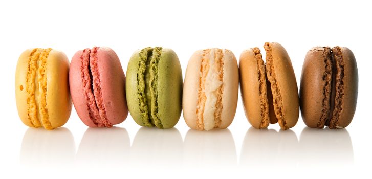 Row of colorful sweet macarons isolated on a white background