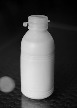 BLACK AND WHITE PHOTO OF PLASTIC BOTTLE OF WHITE MILK