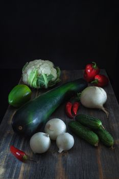 Fresh vegetables of different color, cauliflower and vegetable marrow of zucchini a low key in style a rustic
