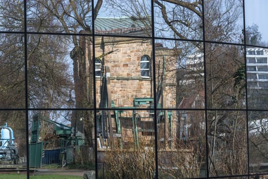 Beautiful glass building facade with reflections of surrounding buildings and nature.