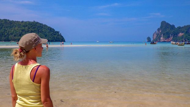 Young woman enjoying the view on the beach in a lagoon of phi-phi Island, Thailand.