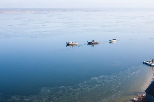 A few small ships in the winter sea near coast