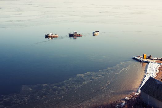 A few small ships in the winter sea near coast