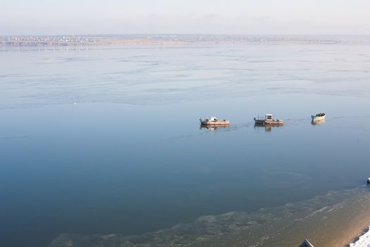 A few small ships in the winter sea near coast