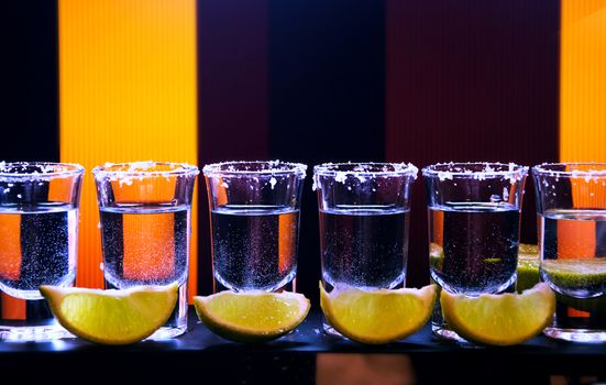 Shot drink set with citrus slices on bar background