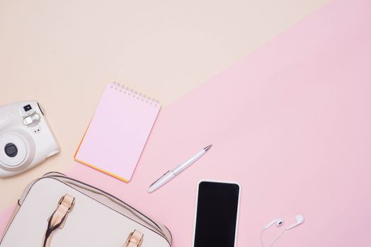 Flat lay of female fashion accessories and white handbag on pastel color background with copyspace