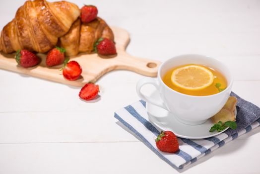 Healthy ginger tea with morning breakfast on a wooden table