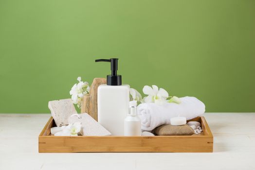 SPA Decoration. Spa composition with cosmetic bottle over green.