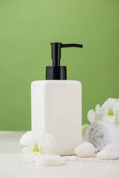 SPA Decoration. Spa composition with cosmetic bottle over green.