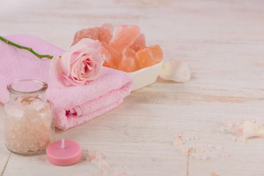 Spa settings with roses. Various items used in spa treatments on white wooden background.