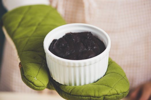 Chocolate homemade dark muffin in mom hands.