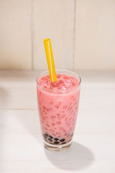 Boba / Bubble tea. Homemade Strawberry Milk Tea with Pearls on wooden table.