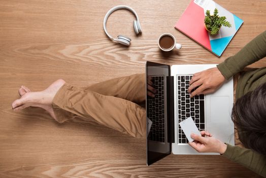 Business man hands using a laptop with a cup of coffee and smart phone with copy space.