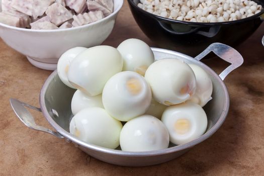 freshly hard-boiled eggs in a small aluminum pan. Waiting for cooking in the kitchen