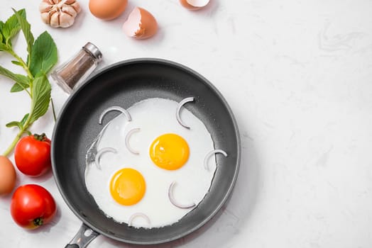 Fried eggs in a frying pan with cherry tomatoes and bread for breakfast