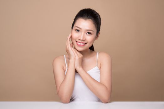 Beauty face. Facial treatment. Young asian woman with clean perfect skin touch her face.