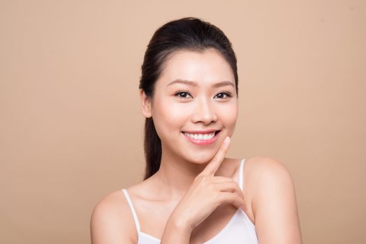 Beauty face. Facial treatment. Young asian woman with clean perfect skin touch her face.