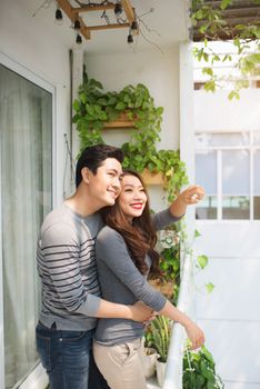 Couple in love sharing genuine emotions and happiness, hugging on the balcony