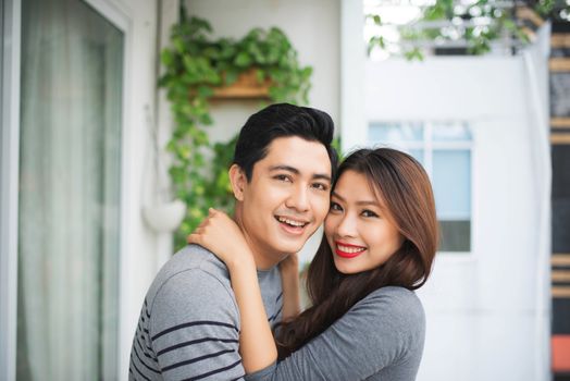 Couple in love sharing genuine emotions and happiness, hugging on the balcony