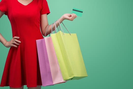 Asian girl showing credit card in hand, over blue background