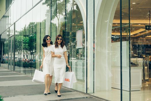 Beautiful asian girls with shopping bags walking on street at the mall