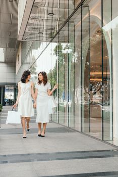 Beautiful asian girls with shopping bags walking on street at the mall