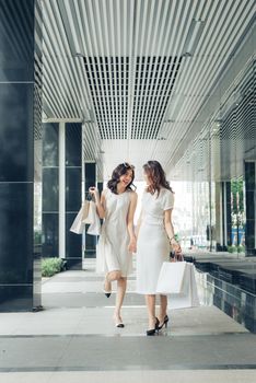 Beautiful asian girls with shopping bags walking on street at the mall
