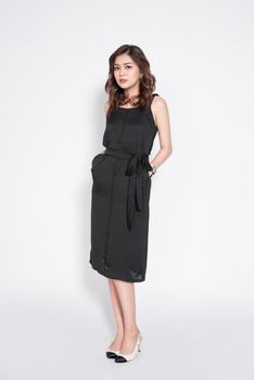 Full length of beautiful stylish asian woman in elegant casual black outfit posing
