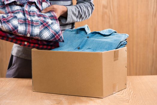 Donation box for poor with clothing in male hands