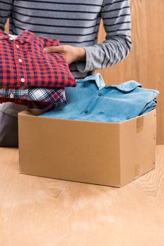 Donation box for poor with clothing in male hands