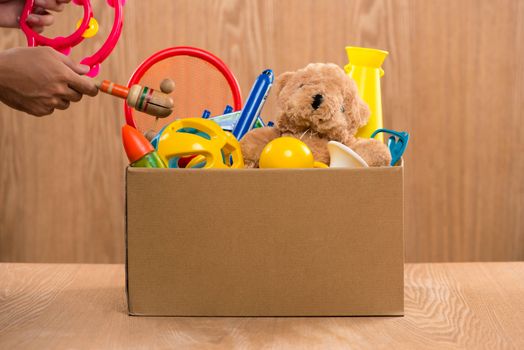 Male volunteer holding donation box with old toys.