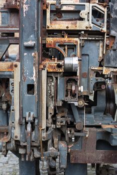Old rusty printing machine complex mechanism of metal with close up details