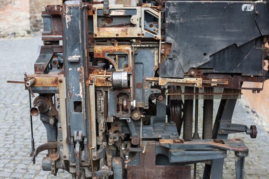 Old rusty printing machine complex mechanism of metal with close up details