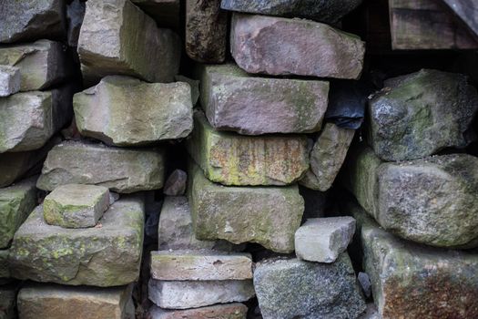 Fragment of a wall from a chipped stone. Stones background with construction materials close up