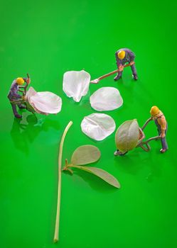 Miniature figures working to create spring cherry flower