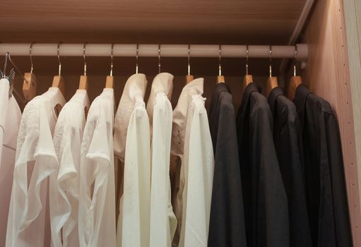 White and black shirts on trempele in the closet.