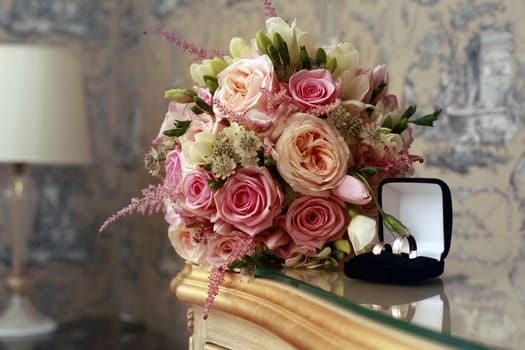 Wedding bouquet from pink roses and rings