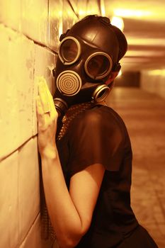 Woman in a gas mask in the night tunnel