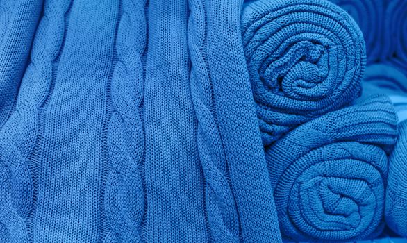 Blue knitted fabric twisted into a roll.