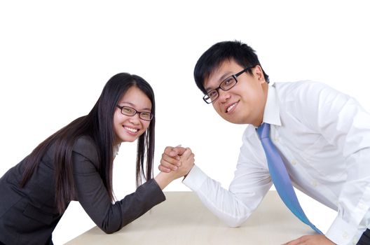 Business man and woman arm wrestling on desk in office