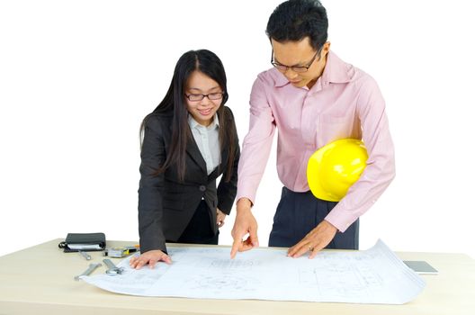 Two architects discussing new project in office. Looking at blueprint.