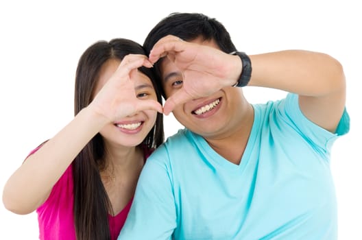 Young couple making heart shape by hands
