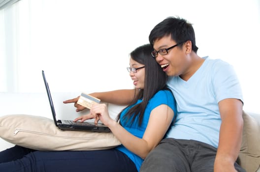 happy young couple with credit card and laptop