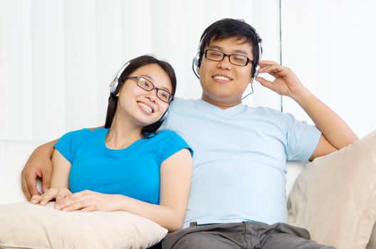 Relaxed young couple with headphones listening music