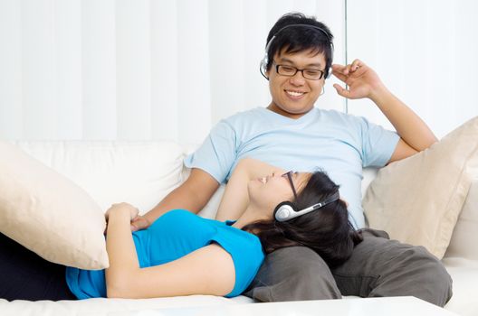 Relaxed young couple with headphones listening music