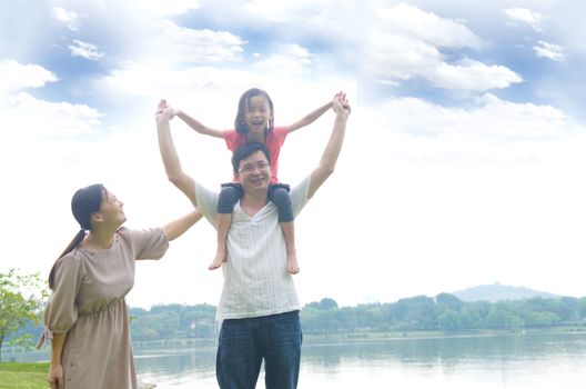 Happy Asian Family enjoying family time together in the park