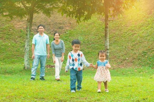 Outdoor portrait of happy asian family