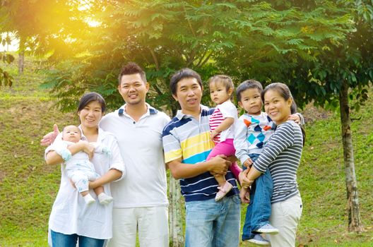 Outdoor portrait of happy asian family
