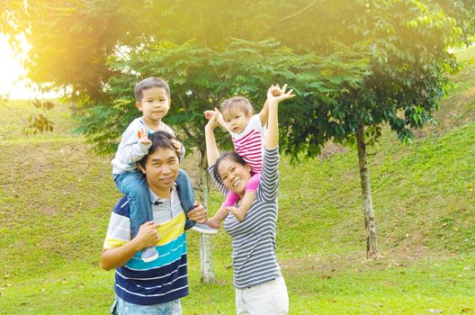 Happy Asian Family enjoying family time together in the park