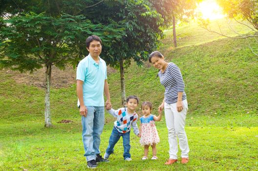 Outdoor portrait of happy asian family